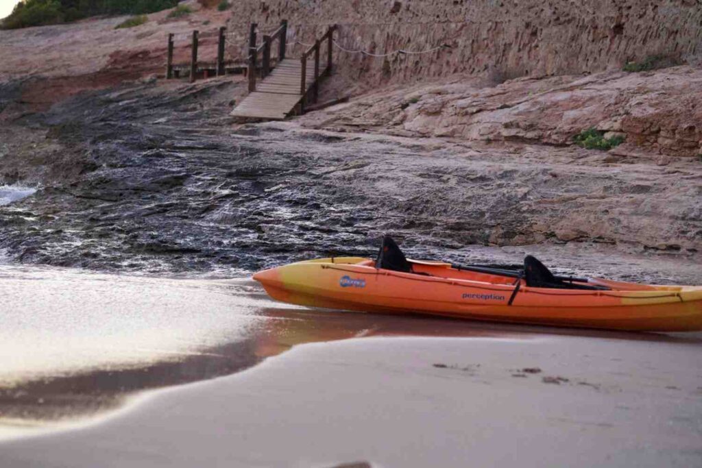 kayak half in water on shore solo entry position calm water