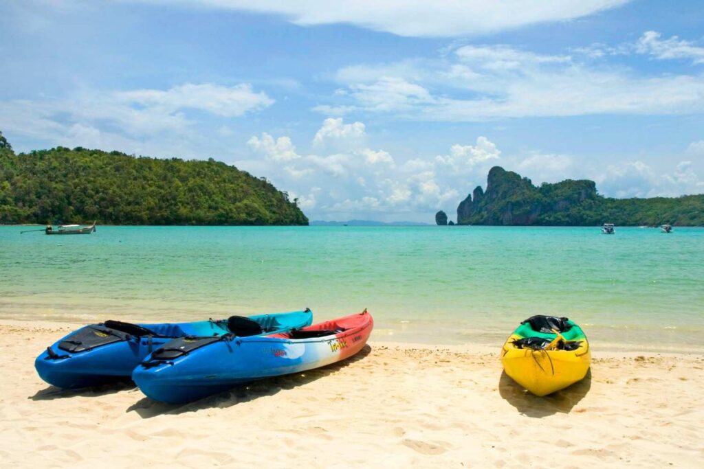 multiple kayaks on calm beach shore ready for entry
