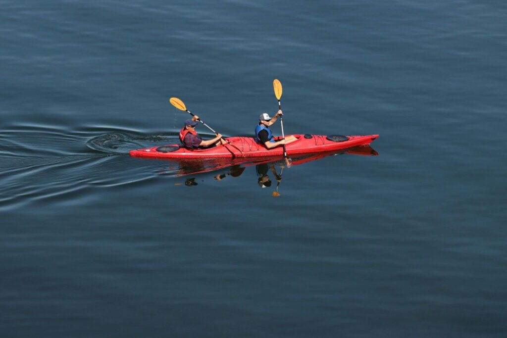two kayakers paddling straight on calm water first water test