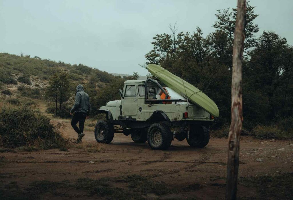 kayak loaded on truck checking straps before driving