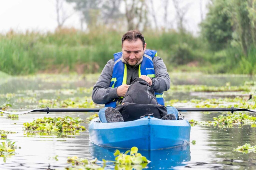kayaker checking kayak gear maintenance on calm water