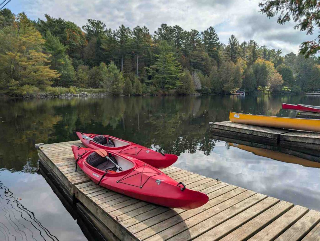 two red kayaks on wooden dock lake ready for entry