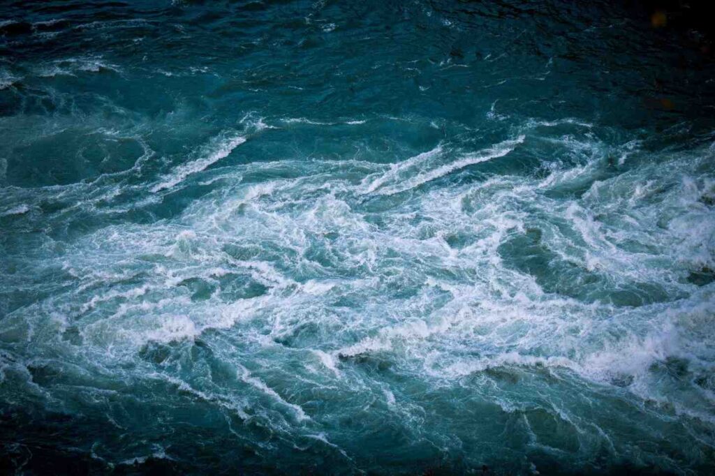 Aerial close-up of churning white water rapids showing the power and unpredictability of river currents