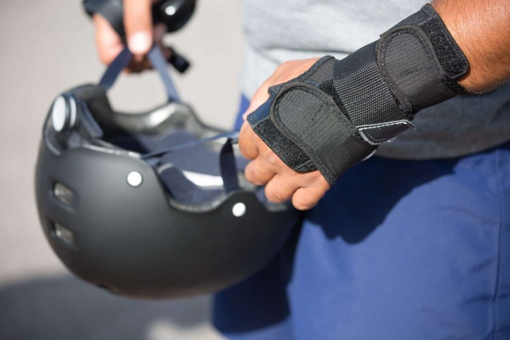 Close-up of a person holding a paddling helmet in their hand instead of wearing it