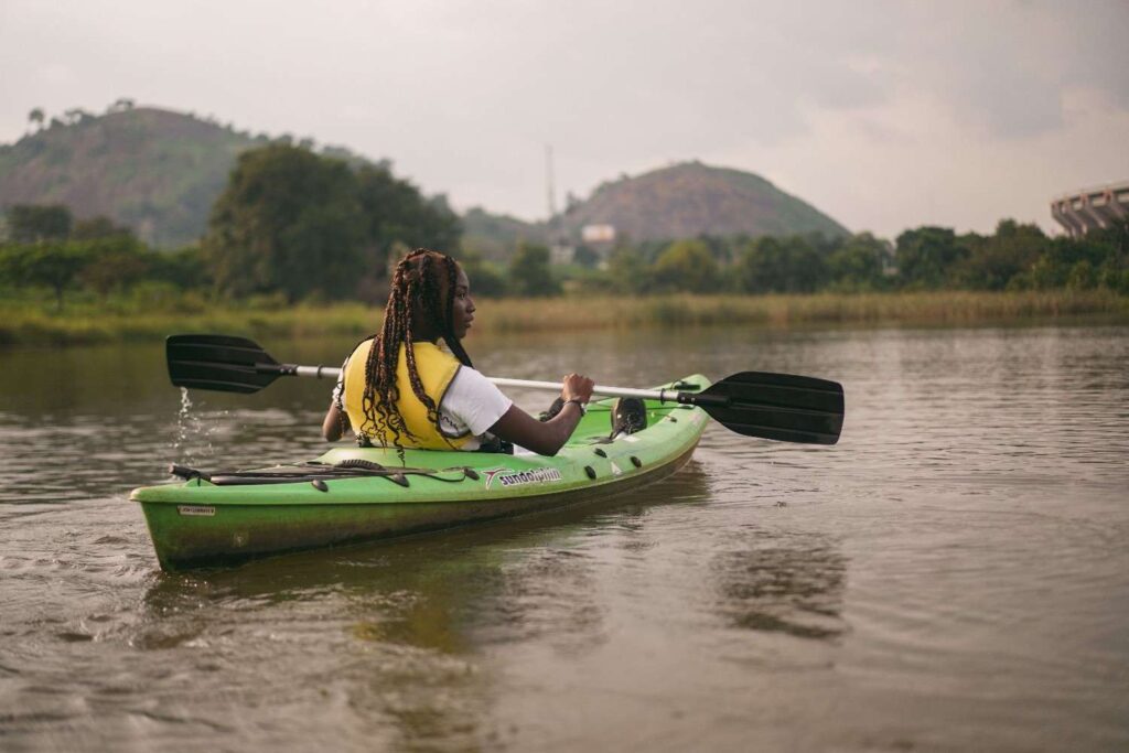 Woman paddling a kayak while wearing a bright yellow life jacket