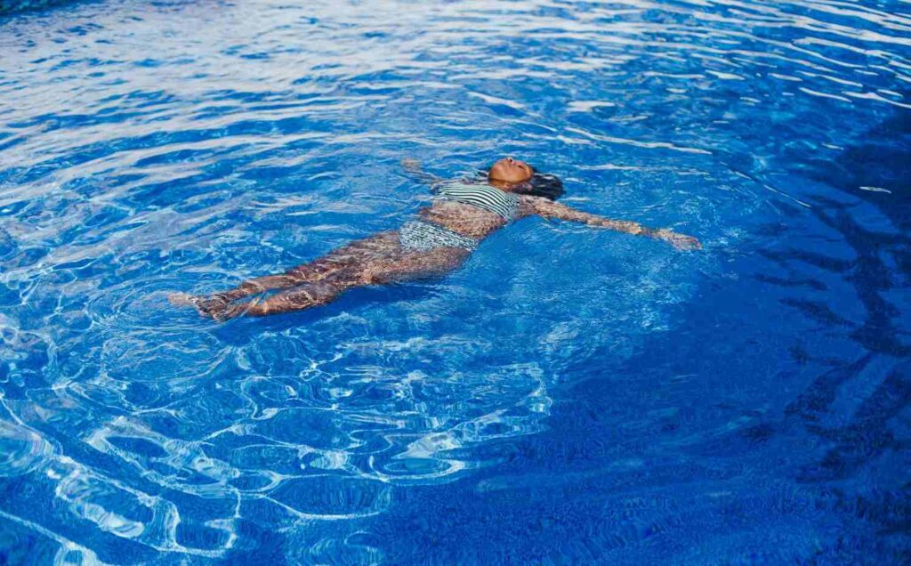 Woman floating peacefully in a pool as a low-impact exercise alternative